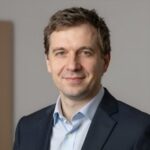Профессиональный портрет уверенного бизнесмена на нейтральном фоне для сайта разработки магазинов Magento